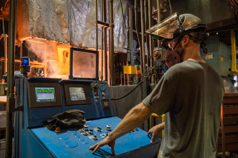 foundry worker at controls of ductile iron casting process