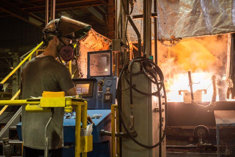 worker overseeing heating of ductile iron in foundry