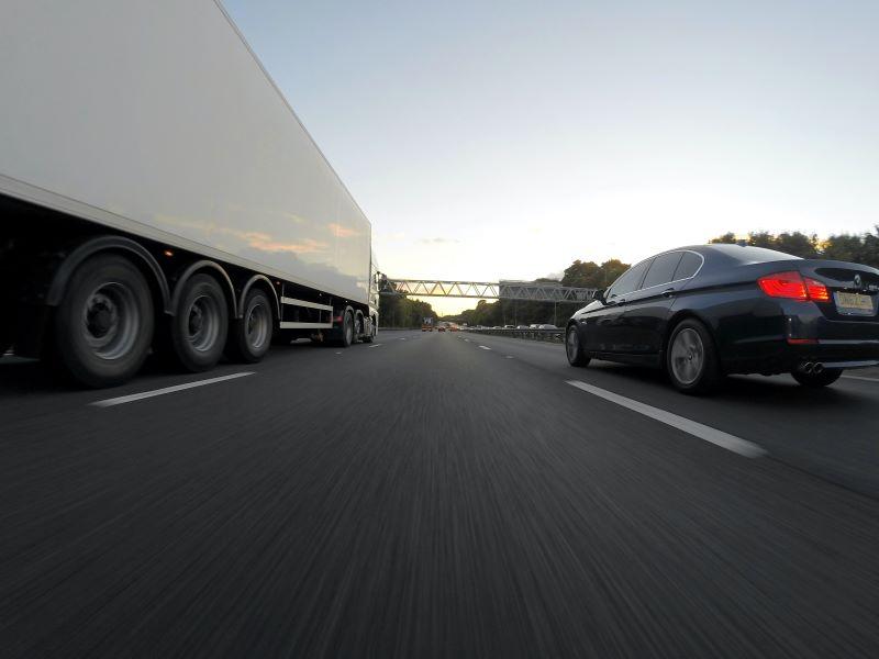 semi built from ductile iron heavy duty truck parts passing car on the highway